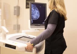 A woman in black scrubs reading a mammogram
