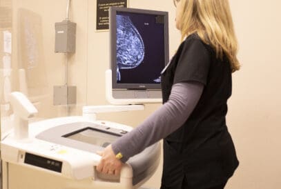 A woman in black scrubs reading a mammogram
