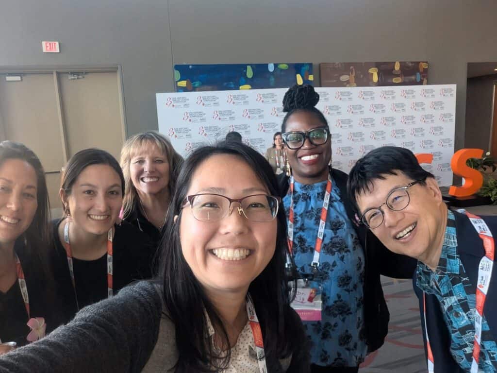Six patient advocates take a selfie in a conference room at SABCS.
