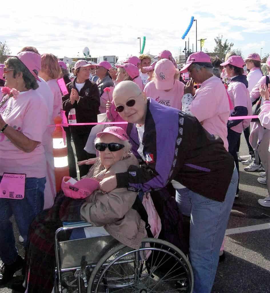 Breast cancer survivor Dixie surround by women in pink.