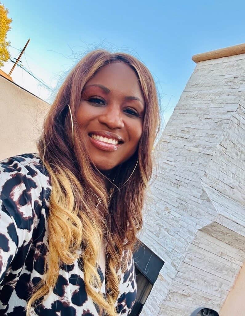 Breast cancer survivor Joi smiles at the camera.