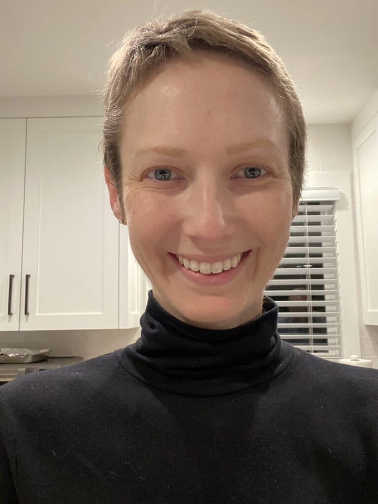 Lauren smiles. She's standing in her kitchen. Her hair is short, just starting to grow back after chemotherapy.