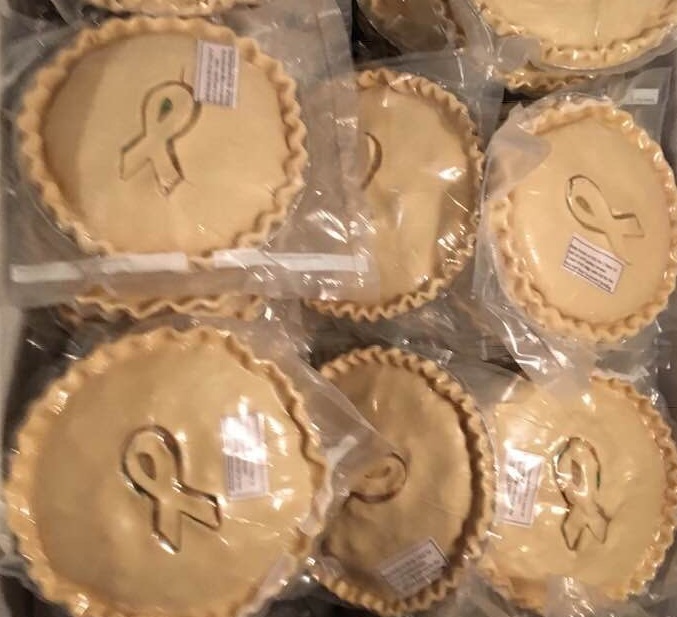 Six frozen pot pies featuring a ribbon promoting breast cancer awareness.
