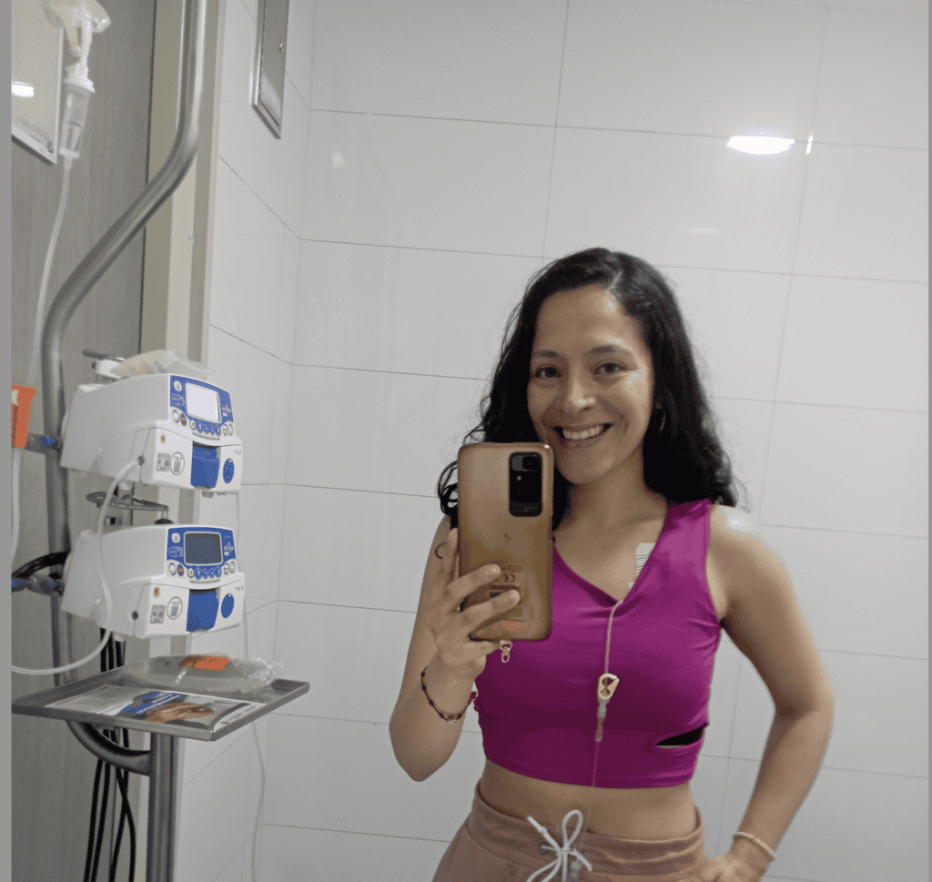 Gynna is living with metastatic breast cancer. She smiles while receiving treatment. 