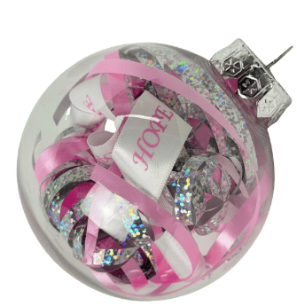 A clear Christmas ornament filled with pink, white, and silver glittery ribbon, including a white ribbon with the word “HOPE” printed in pink—perfect for showing your support for breast cancer awareness this holiday season.