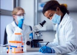 Two,Female,Lab,Workers,Wearing,Ppe,And,Safety,Glasses,Looking