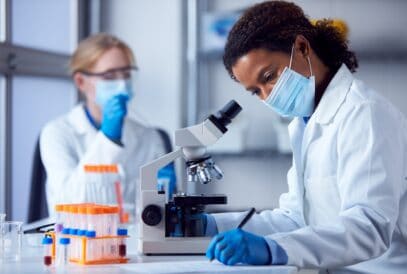 Two,Female,Lab,Workers,Wearing,Ppe,And,Safety,Glasses,Looking