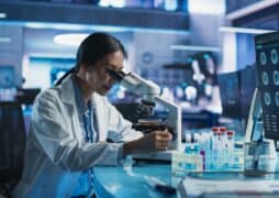 Medicine,Development,Laboratory:,Asian,Female,Scientist,Using,Microscope,,Analyzes,Petri