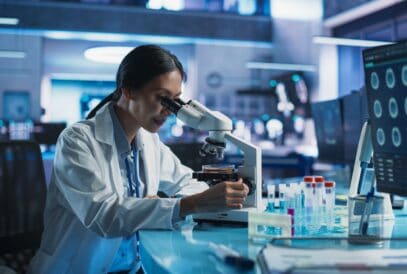 Medicine,Development,Laboratory:,Asian,Female,Scientist,Using,Microscope,,Analyzes,Petri